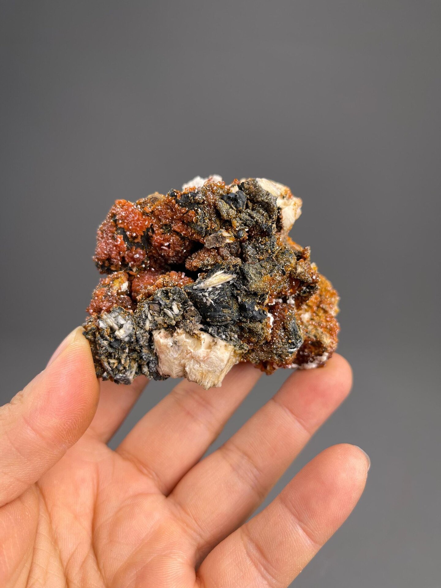 Front view of deep red vanadinite crystals on white barite matrix