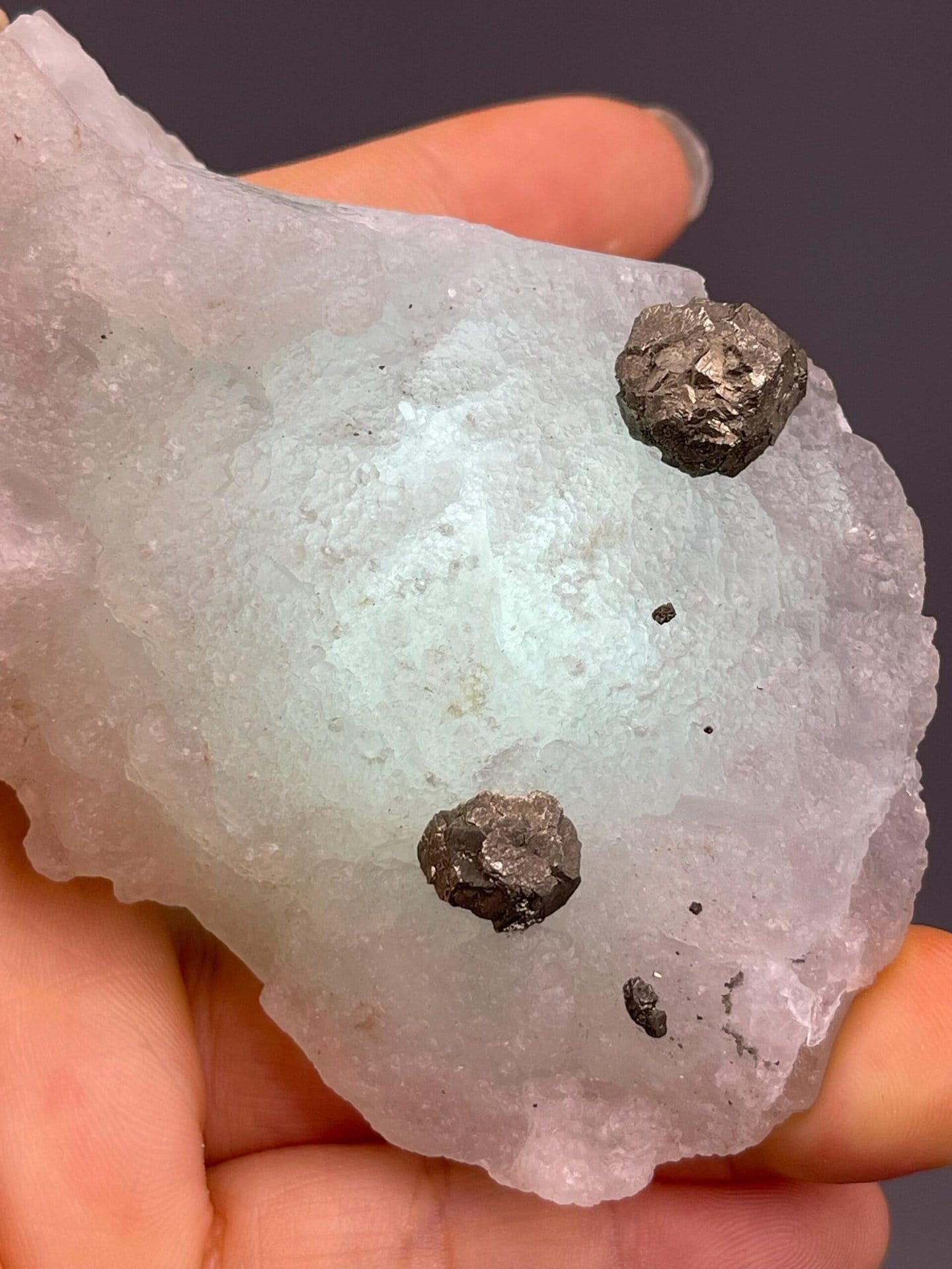 Close-up of metallic iron ore embedded in green fluorite