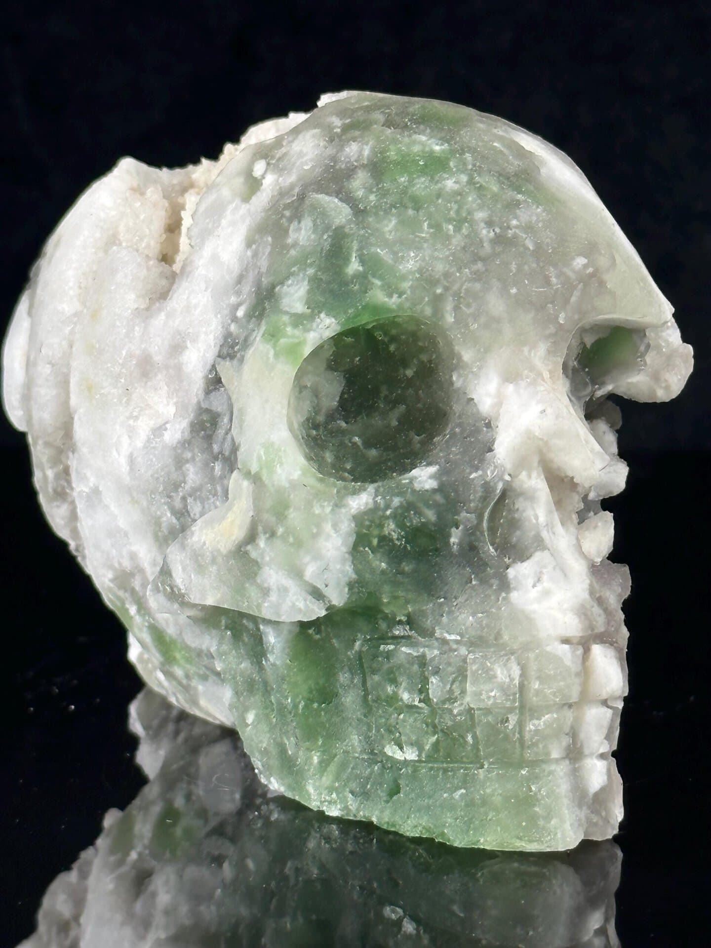 Front view of large hand-carved fluorite skull with geode