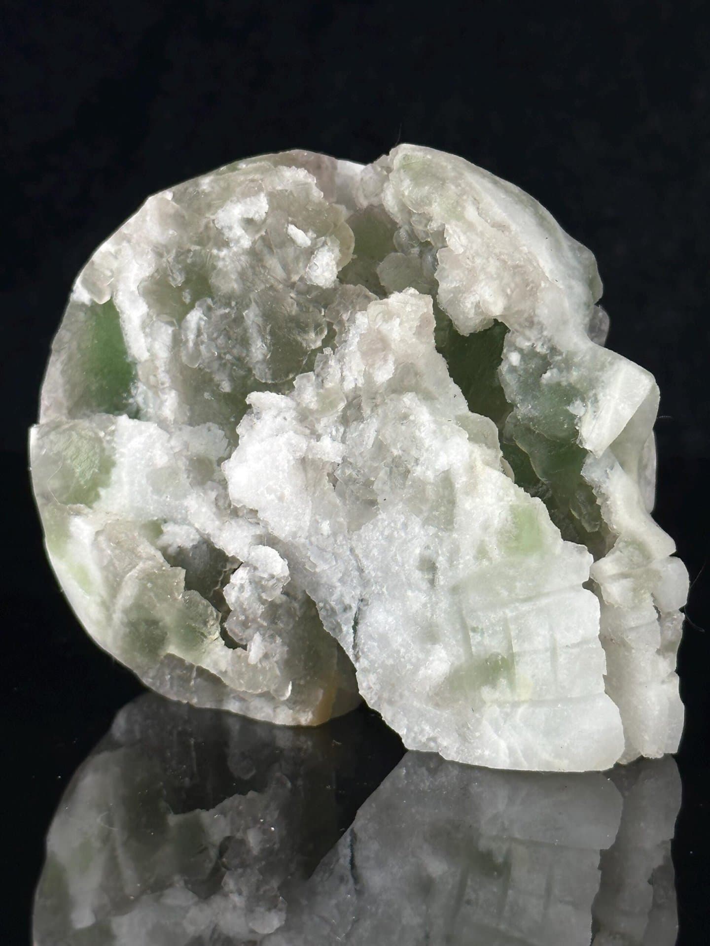 Side profile of carved fluorite skull with geode
