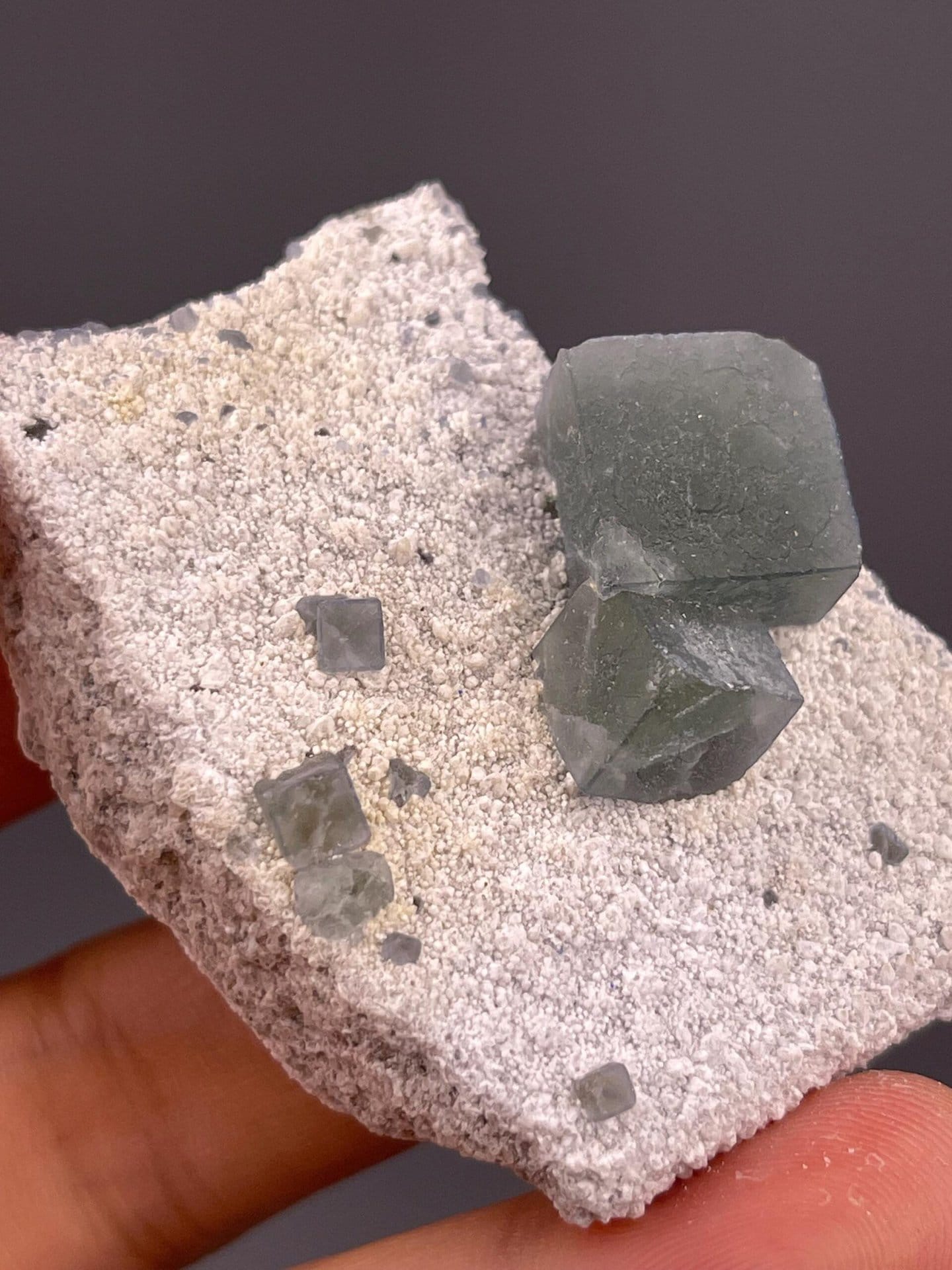 Angled view of green cubic fluorite on light sandy matrix