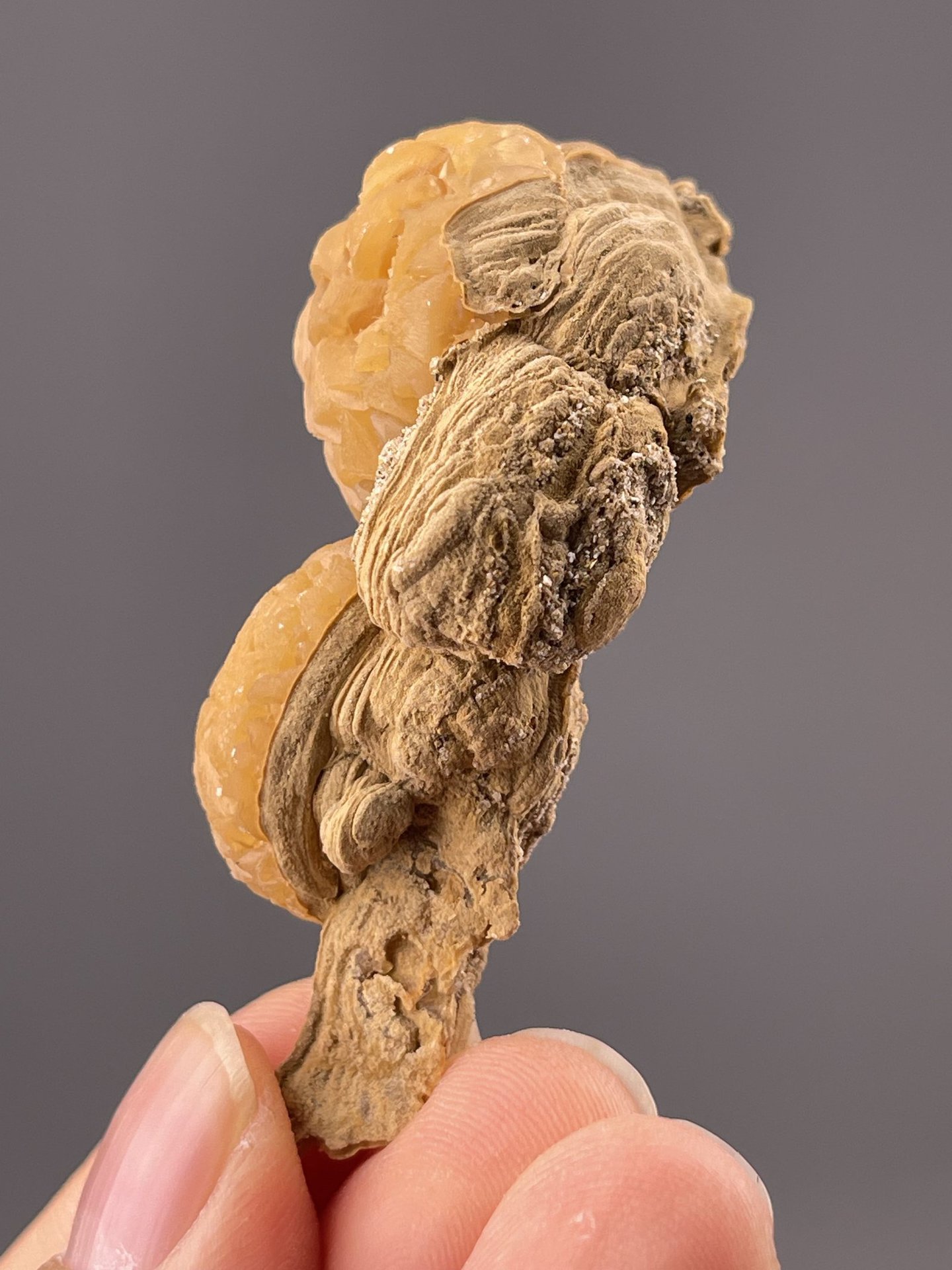 Side view of orange calcite showing rounded globular surfaces