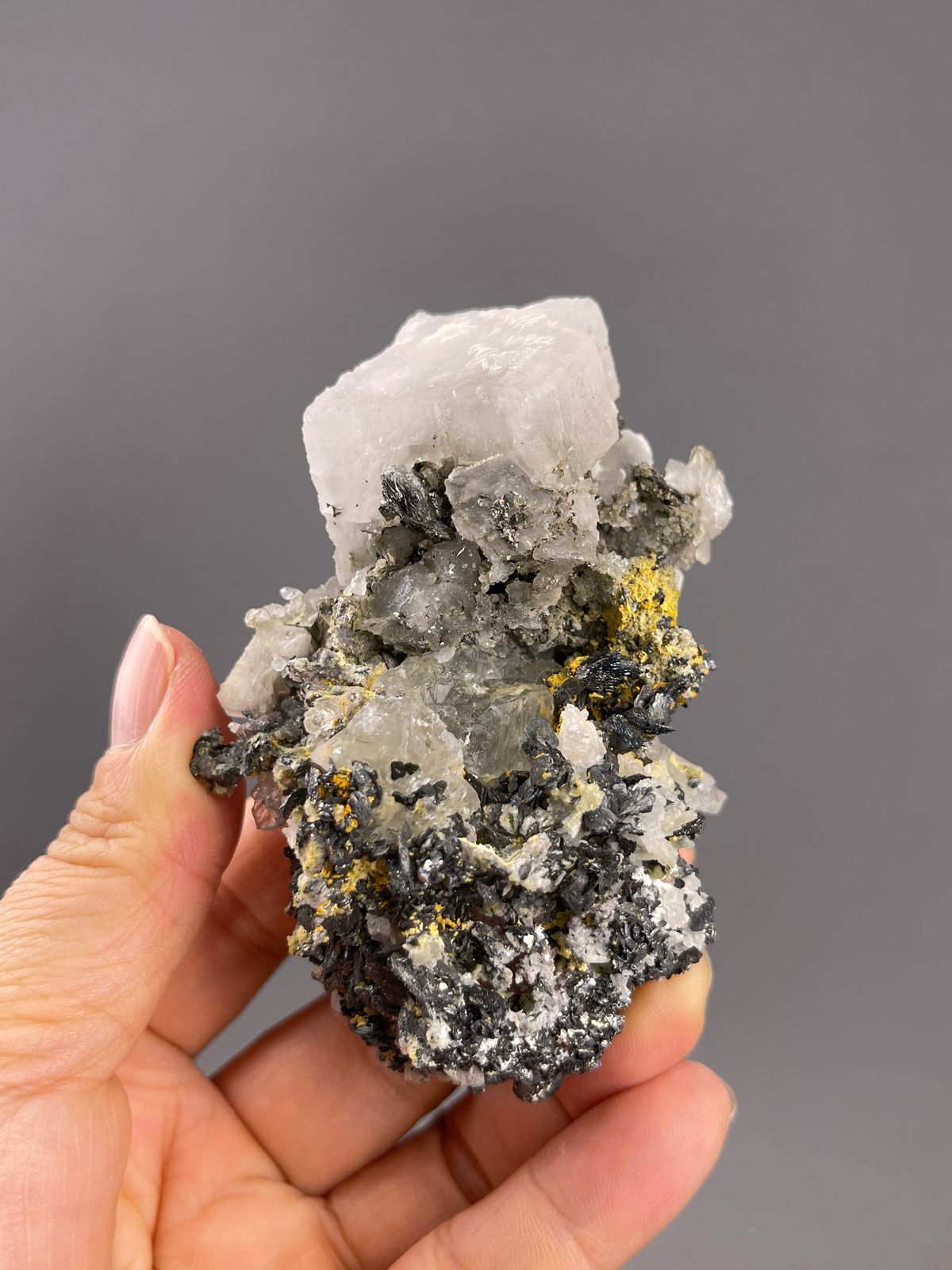 Calcite from Inner Mongolia, China: upright association with a pale end crystal and dark granular base.