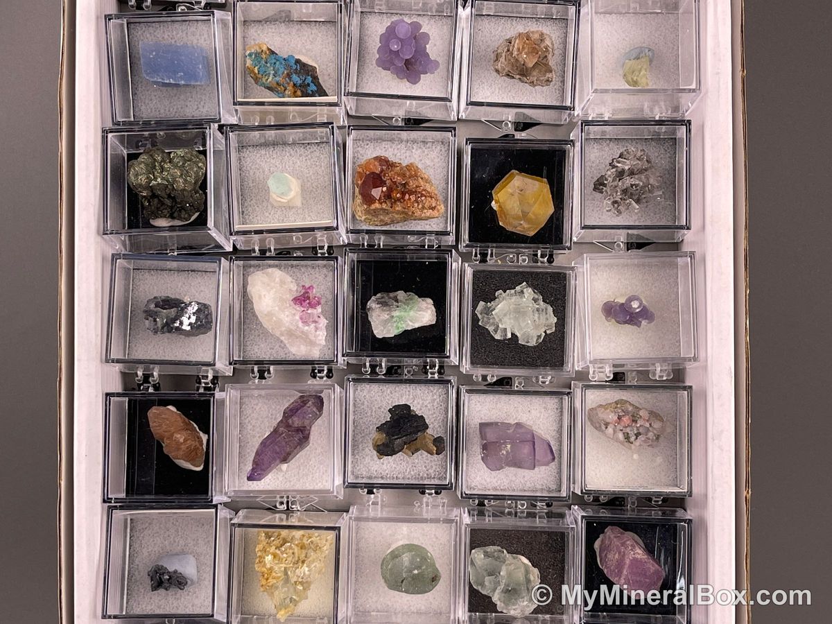 Bulk001 actual mixed mineral specimen box with about 35 different mini natural specimens in clear display boxes, including likely fluorite, quartz, aquamarine, pyrite, grape agate and other assorted minerals.