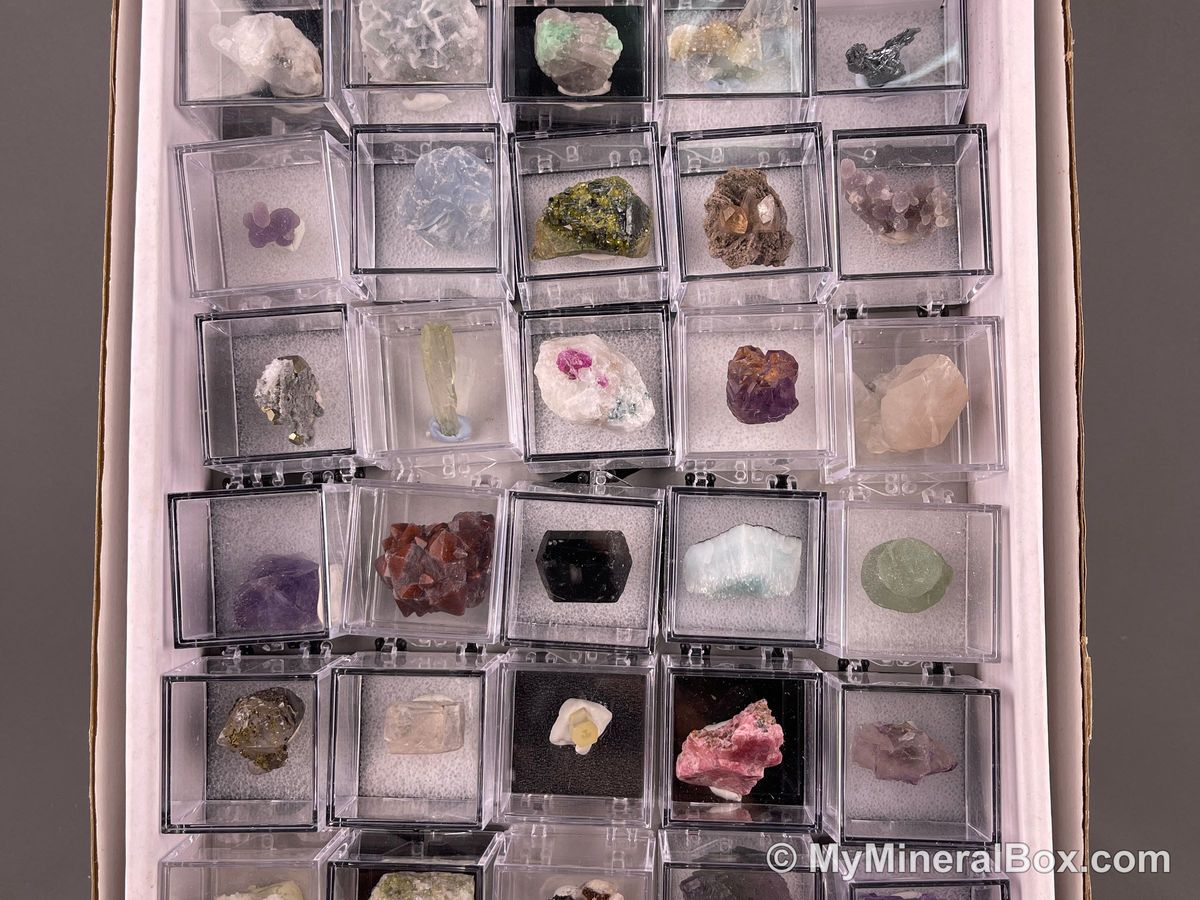 Bulk004 actual mixed mineral specimen box with about 35 different mini natural specimens, including likely fluorite, black tourmaline, quartz, stibnite, grape agate and green prehnite-type material.