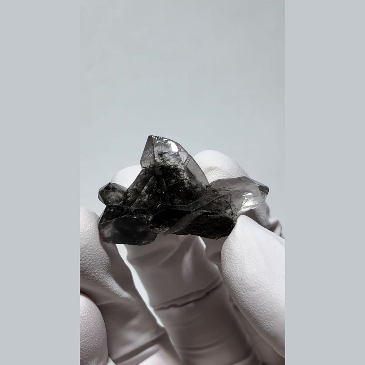 Small smoky quartz cluster with dark hair-like inclusions from Pakistan — complete view