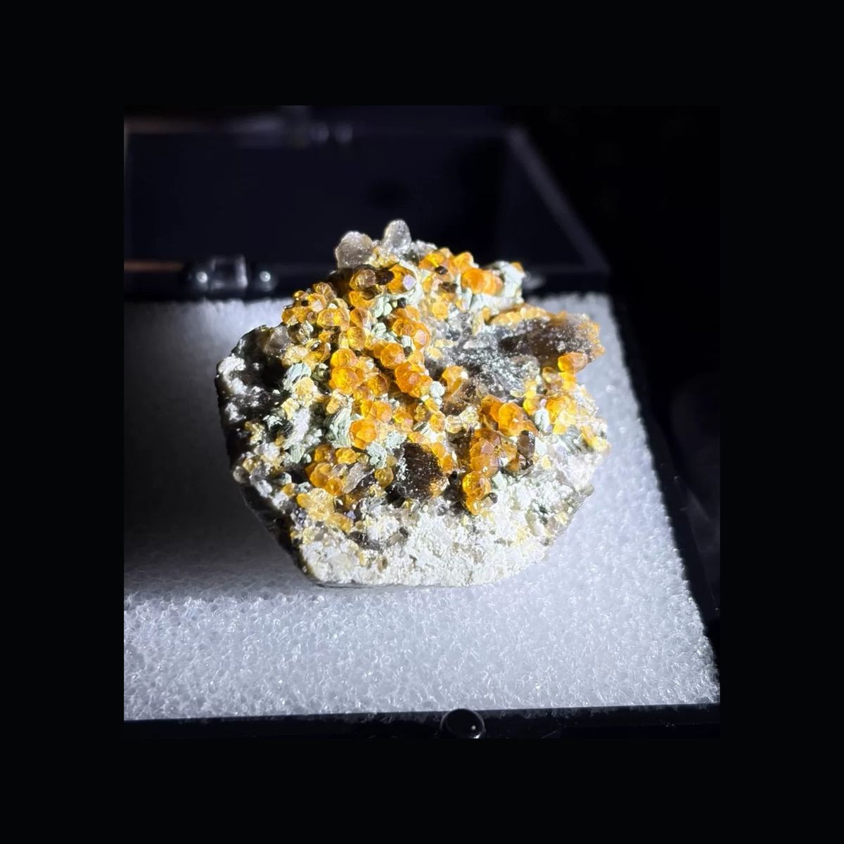 Whole front view of orange spessartine with smoky quartz from Yunxiao