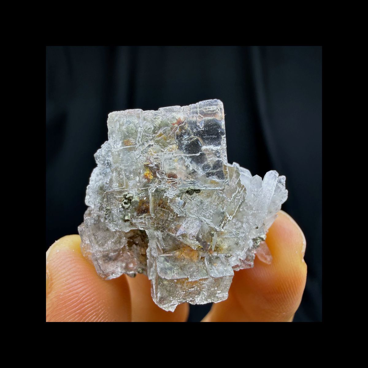 Complete front view of colorless fluorite with pyrite and quartz