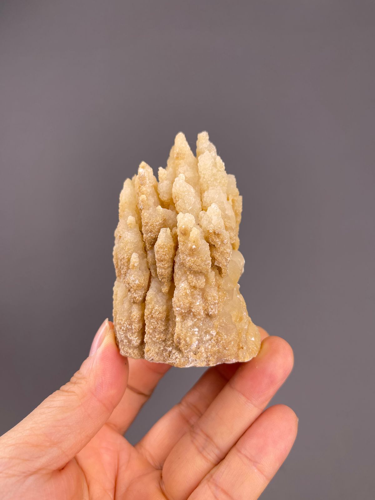 Unidentified specimen from Yunnan, China: whole beige group of pointed towers above a broad base.