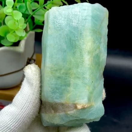 Stout sea-green aquamarine prism from Fujian, China, held in gloved hand