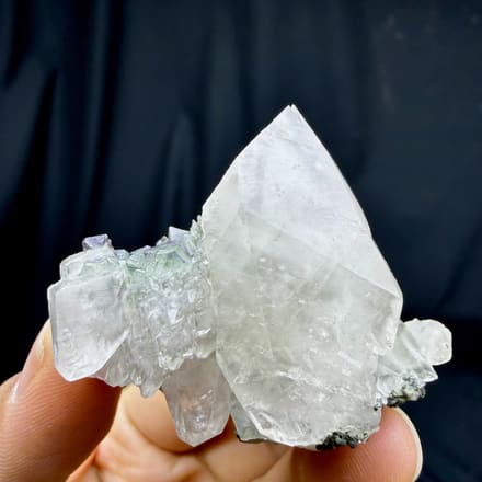 Large double-terminated calcite with green fluorite octahedra from Fujian, China, held in hand