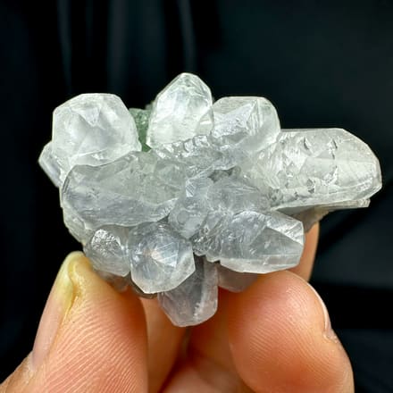 Stepped green fluorite with calcite, from Fujian, China, front view in daylight, held in hand