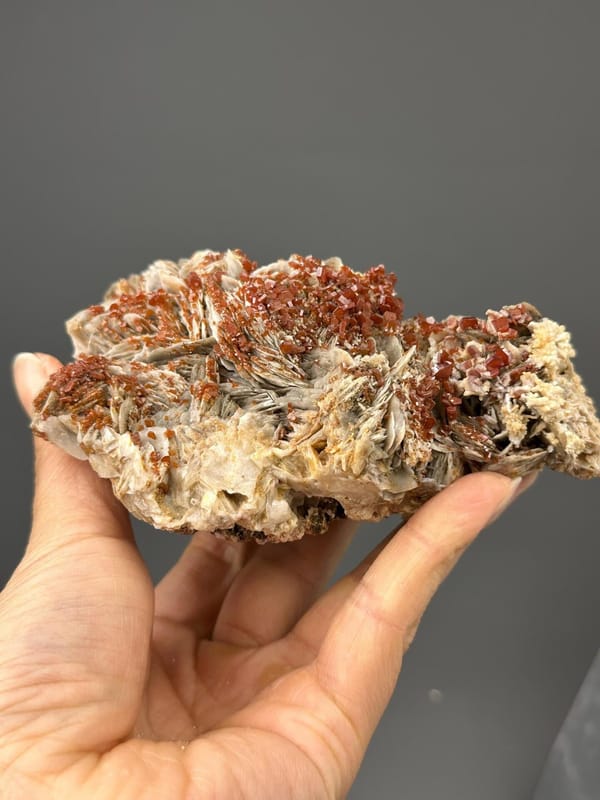 Angled view highlighting red vanadinite against white barite
