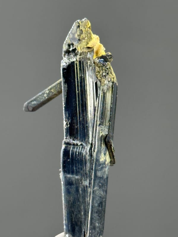 Angled view of stibnite crystal showing metallic brilliance