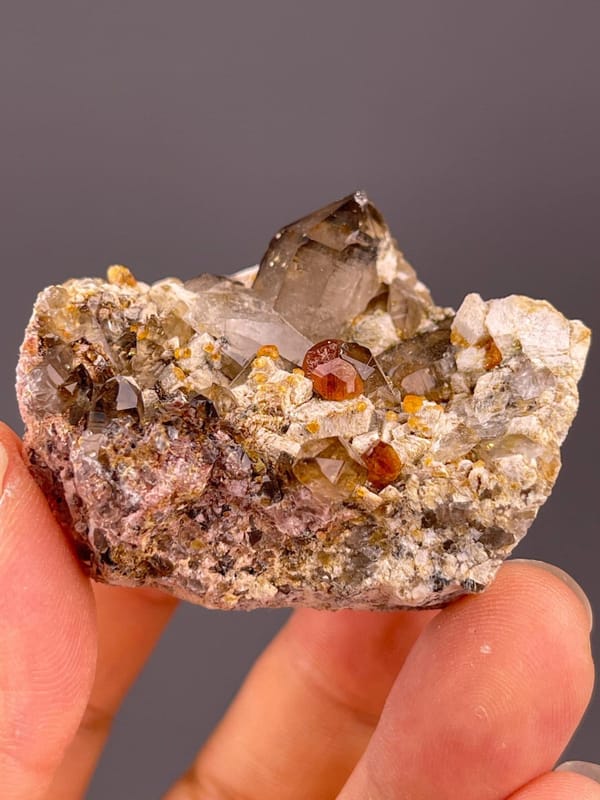 Smoky quartz with garnet and dolomite multi-mineral specimen