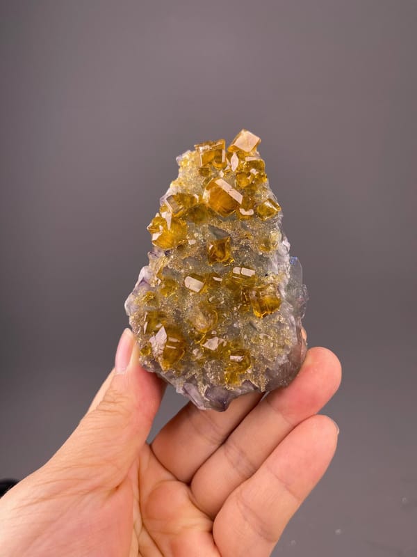 Front view of golden fluorite cluster on baryte matrix