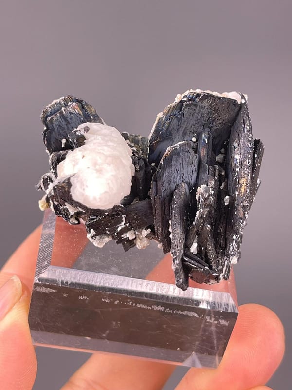 Tetragonal cassiterite beside fluorescent calcite matrix