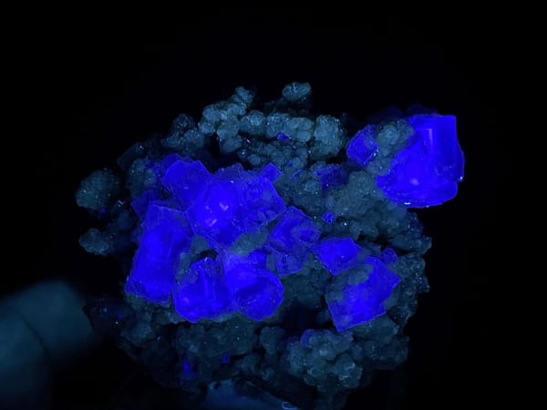 Purple phantom fluorite on green base displaying vitreous luster