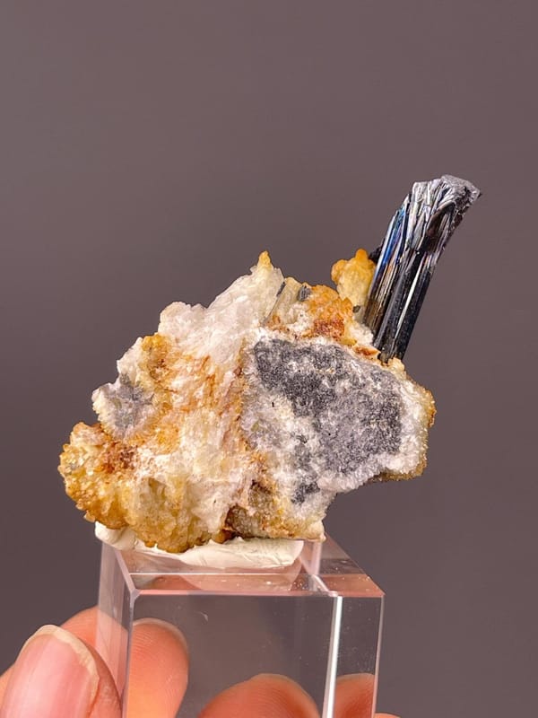 Single sharply defined stibnite prismatic crystal on matrix