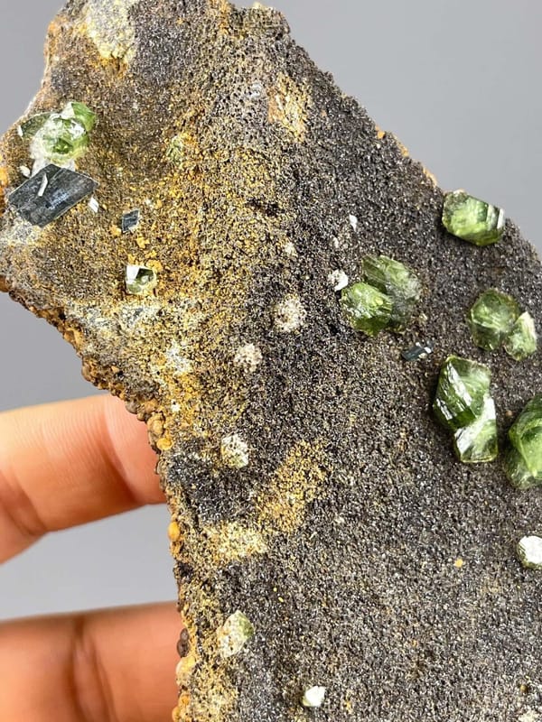Top view of green andradite garnet on dark matrix, Guangxi