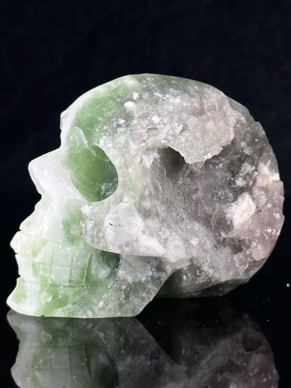 Hand-carved green fluorite skull with raw geode interior from China