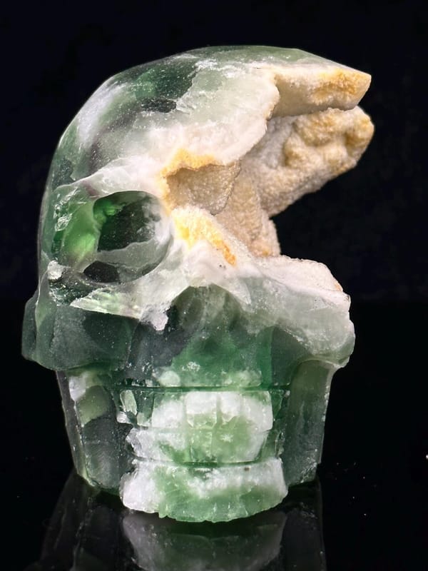 Hand-carved green fluorite skull with geode crystal interior
