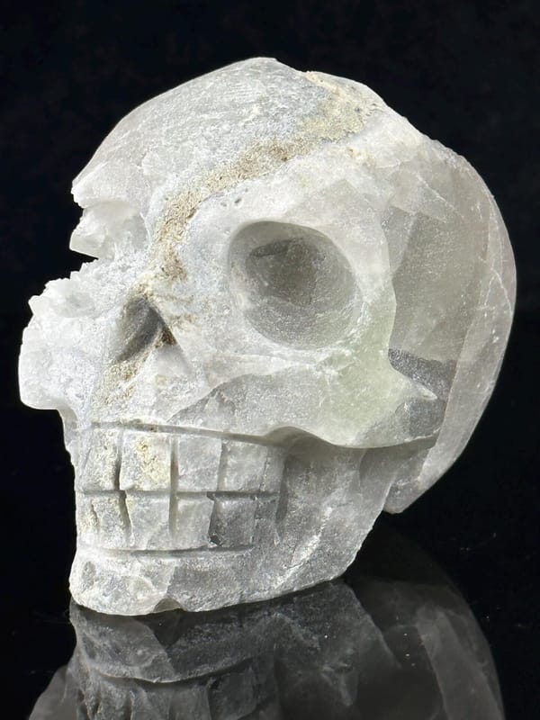 Hand-carved fluorite skull with natural quartz geode interior