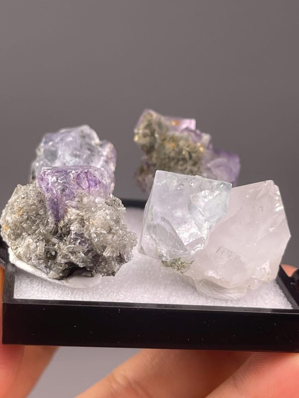 Four matching purple fluorite cubes arranged together