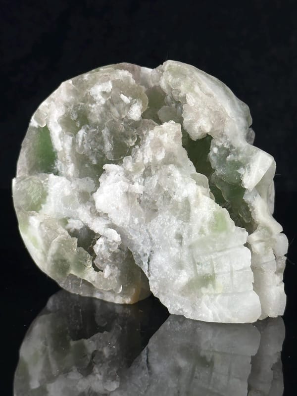Side profile of carved fluorite skull with geode