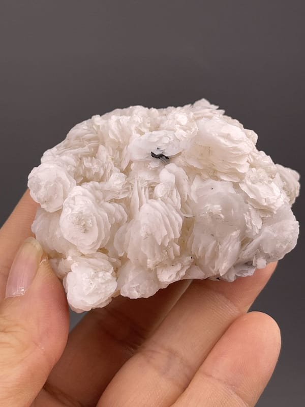 Silky white layered calcite showing fibrous crystal texture, 4.1 g