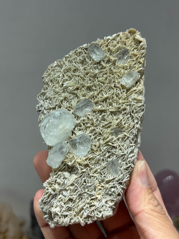 Plate of tan mica with pale aquamarine crystals from Xuebaoding, Sichuan, China, close-up of the crystal faces