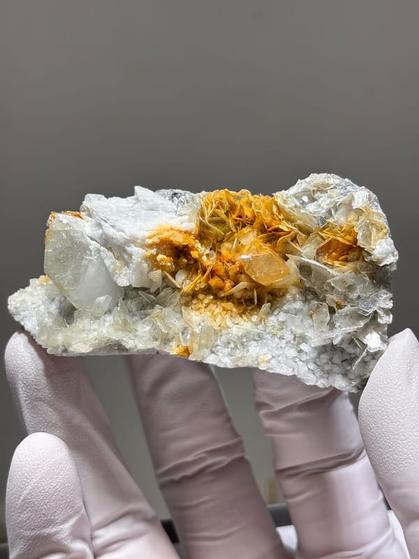 White feldspar plate with aquamarine, orange scheelite and mica from Xuebaoding, Sichuan, close-up of the crystal faces