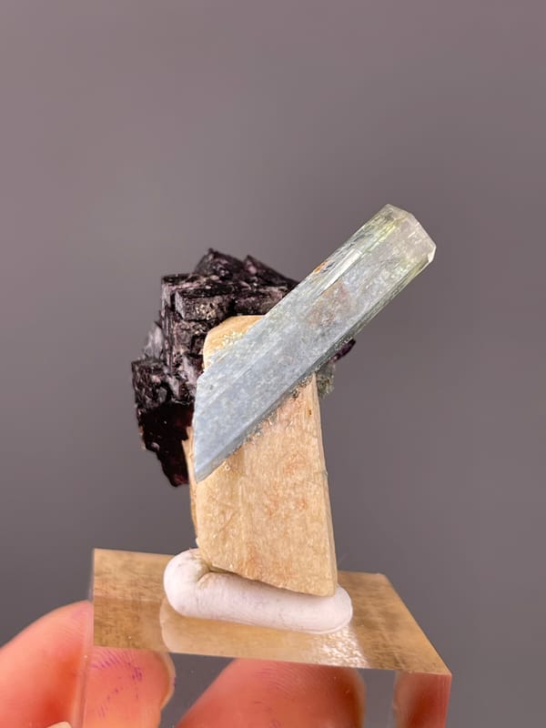 Pale-blue beryl crossing black schorl clearly visible on this aquamarine specimen