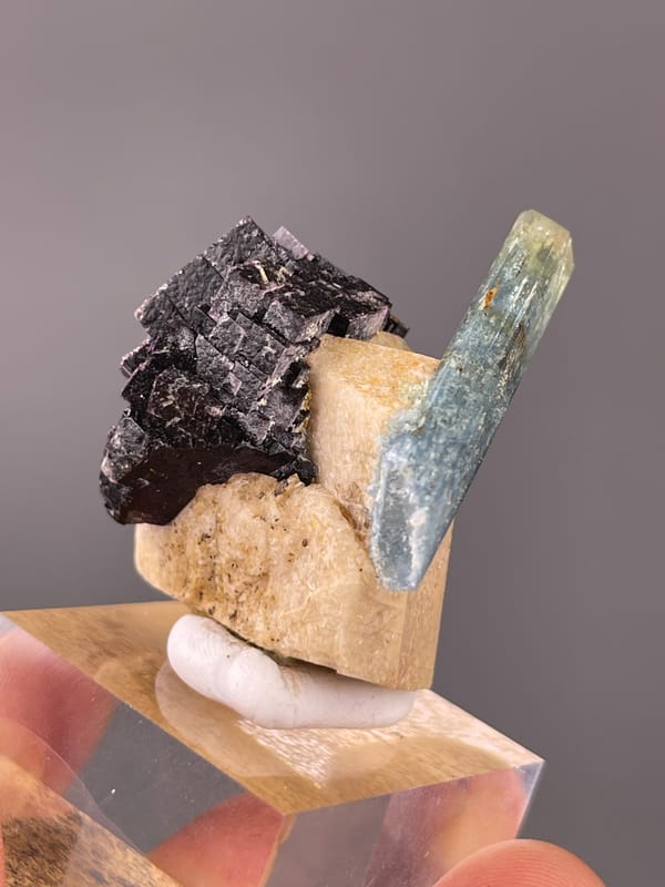 Aquamarine specimen displaying pale-blue beryl crossing black schorl prominently