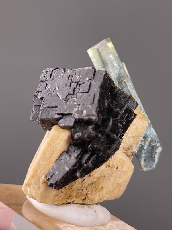 Aquamarine natural specimen highlighting pale-blue beryl crossing black schorl clearly