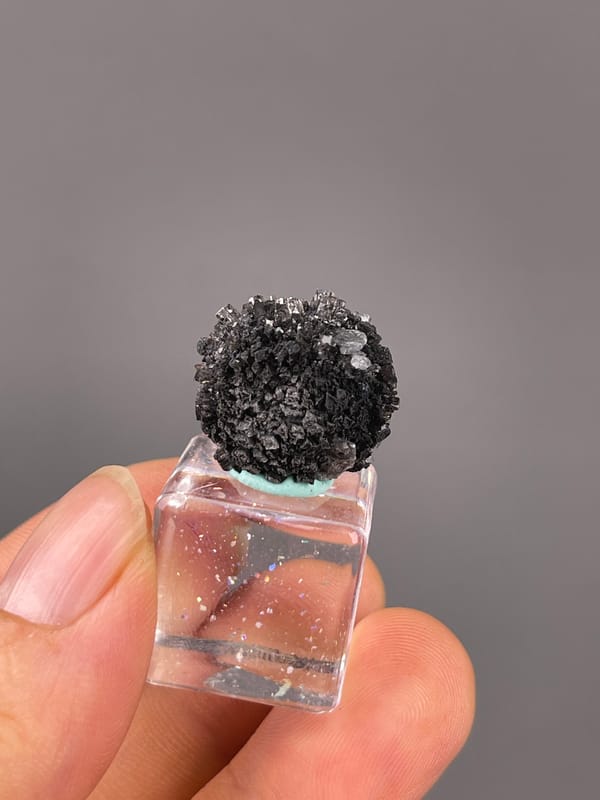 Black spherical radiating aggregate visible on aurora calcite specimen from Longyan, Fujian, China