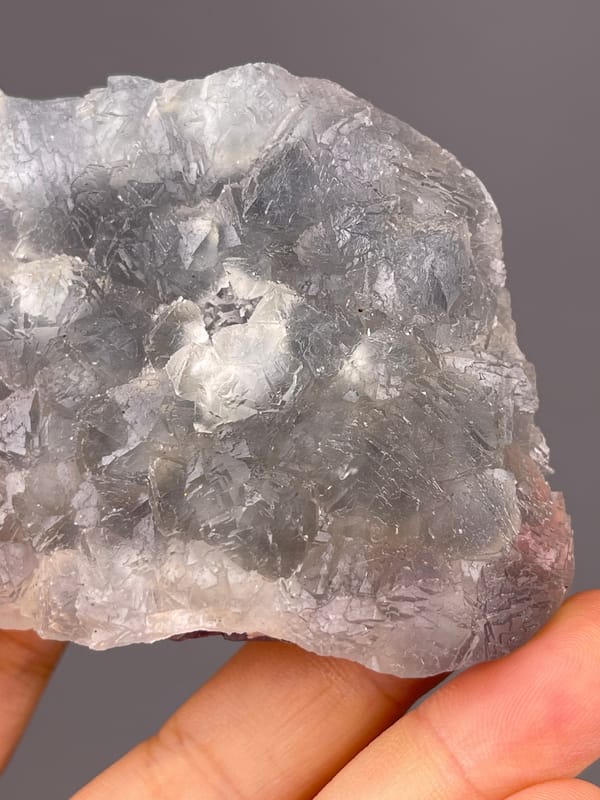 Gray-lilac aggregates with pale coating visible on bi-color fluorite specimen from Zhejiang, China