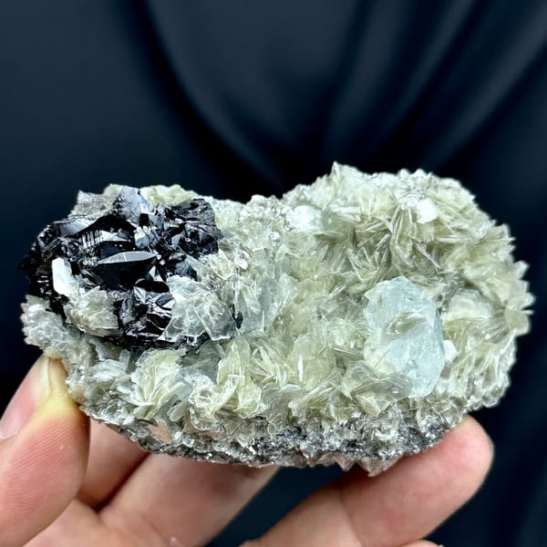 Black cassiterite and pale aquamarine prism on muscovite from Xuebaoding, Sichuan, China, second angle