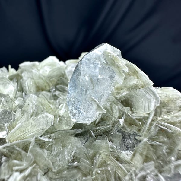 Black cassiterite and pale aquamarine prism on muscovite from Xuebaoding, Sichuan, China, close-up of the crystal faces