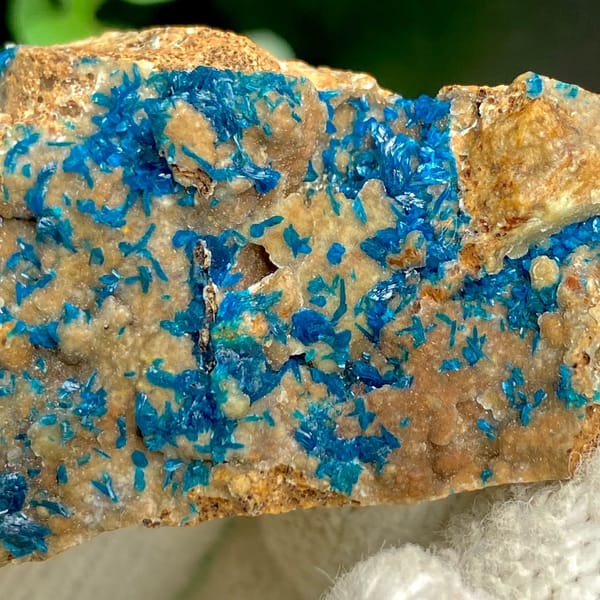 Blue veszelyite crystals spread across tan plate from Yunnan, China, view 3 of 9