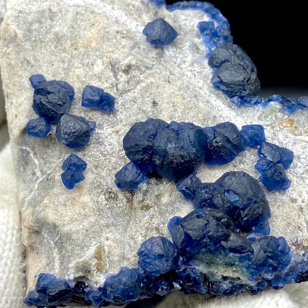 Navy-blue strawberry quartz balls and blue fluorite on pale plate from Inner Mongolia, China, view 3 of 9