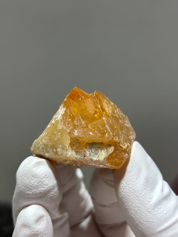 Bright orange scheelite crystal with floater base from Xuebaoding, Sichuan, China, close-up of the crystal faces