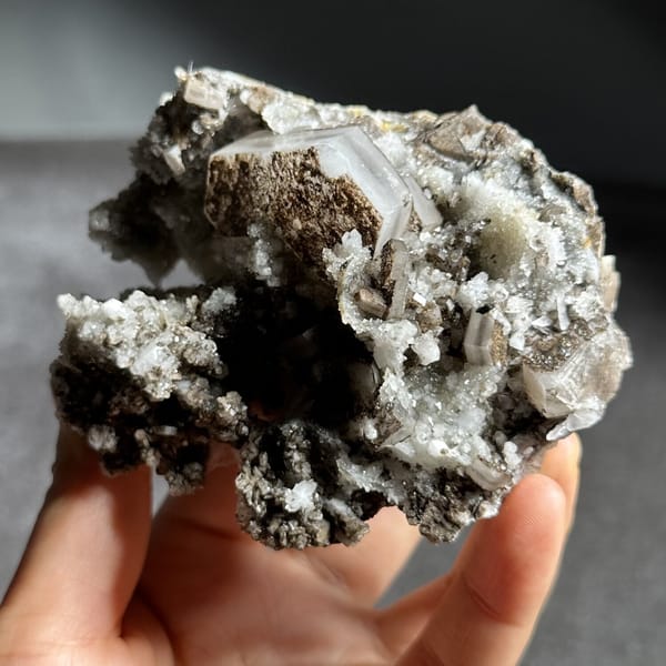 Brown hexagonal calcite plate on grey quartz from Fujian, China, view 12 of 12