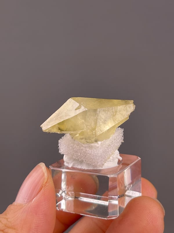 Calcite from Daye, Hubei, China: pale yellow flattened crystal on a display support.