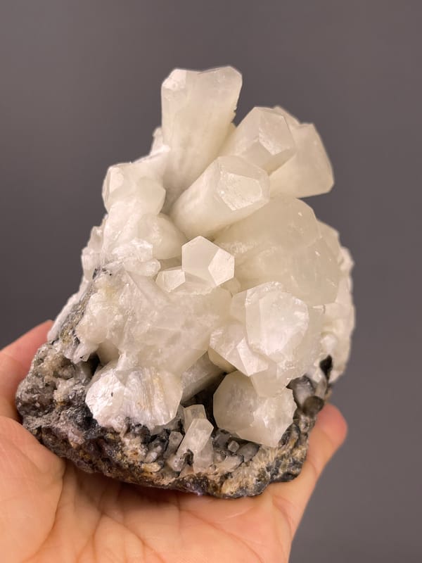 Calcite from Fujian, China: white columns rising from dark matrix.