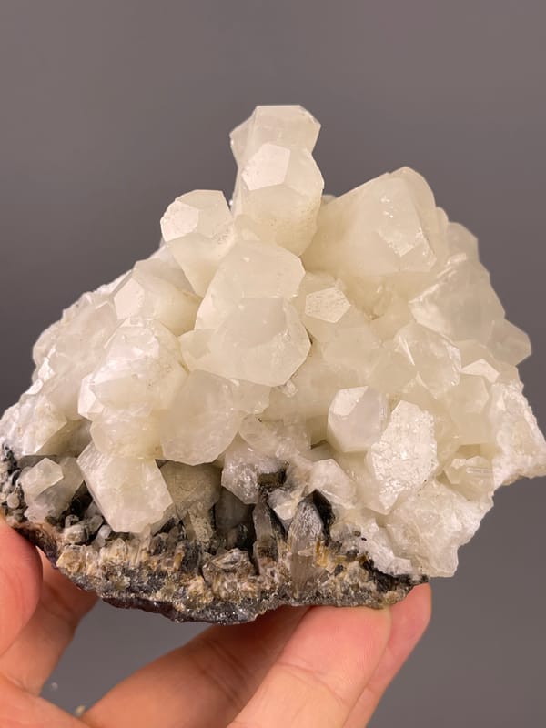 Calcite from Fujian, China: white crystal group above rough matrix.