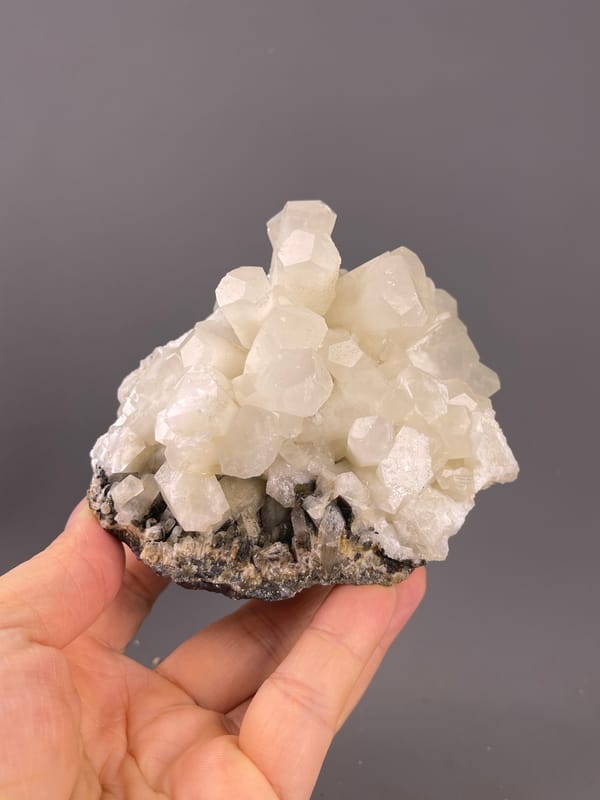 Calcite from Fujian, China: whole cluster held above the palm.