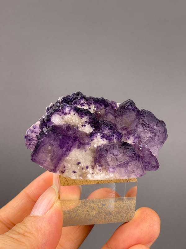 Calcite from Guizhou, China: front angle showing violet edges around pale granular areas.