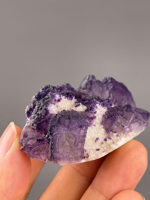 Calcite from Guizhou, China: oblique view showing dark violet borders and pale patches.