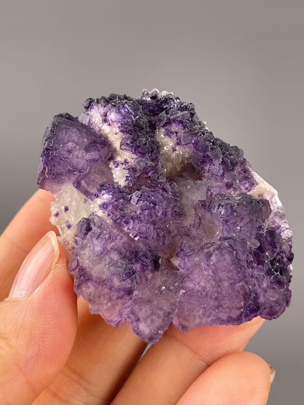 Calcite from Guizhou, China: rotated face with dark violet seams and uneven crystal margins.